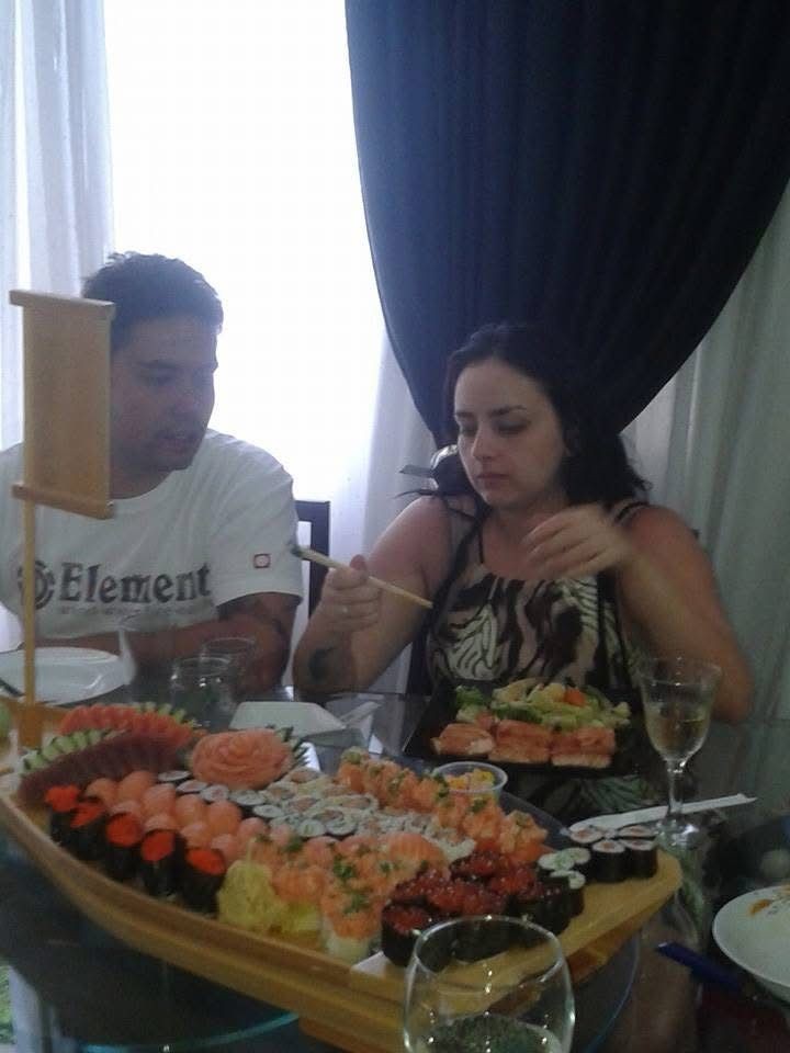 Francesco e Carolline diante do barco de sushi preparado por ele